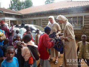 Surorile ajută copiii să pună pe spate, pentru a le duce spre casă, alimentele donate  de surorile din Polonia, care le-au învăţat să lucreze cu săracii