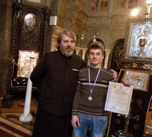 Alături de părintele Petru Suciu,  de la parohia Sfinţii Împăraţi Constantin şi Elena, care l-a premiat pentru  performanţa sa în matematică.